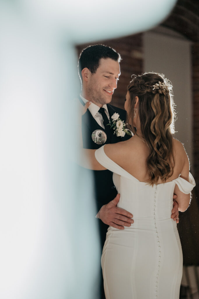 artistic photo peering at bride and groom during first dance