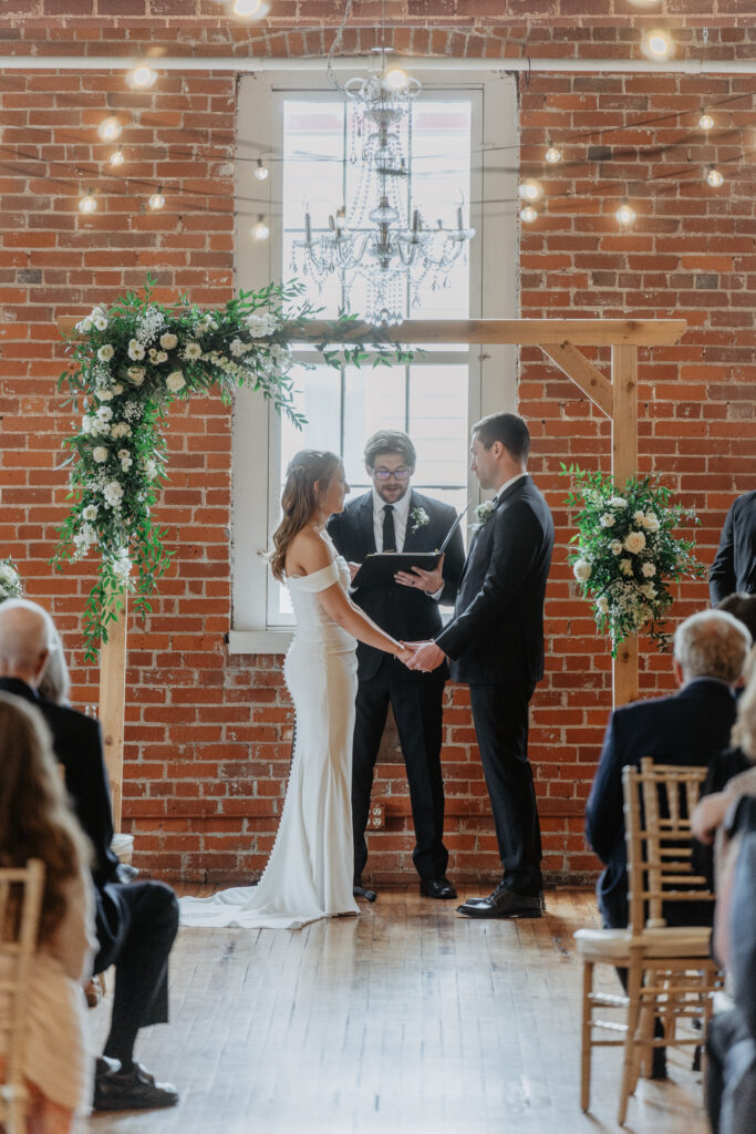 bride and groom holding hands during timeless wedding ceremony