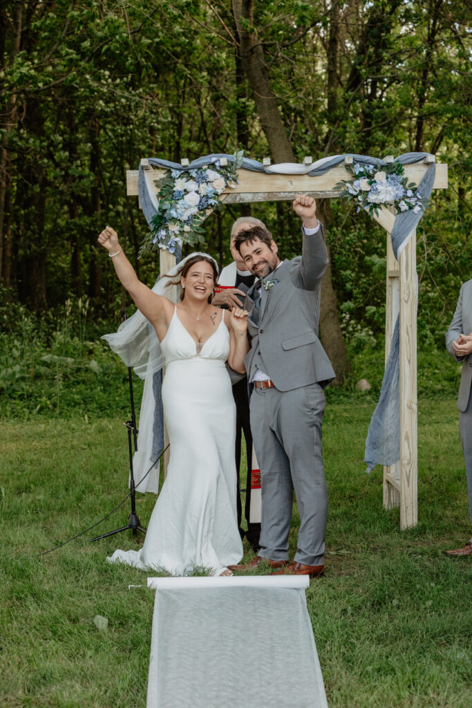 bride and groom cheering after ceremony kiss at Deer Lake Orchard wedding