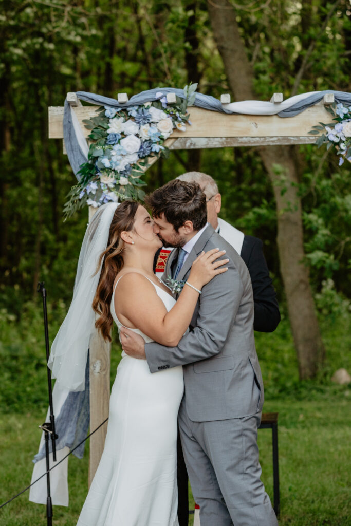 bride and groom ceremony kiss at rustic Deer Lake Orchard wedding