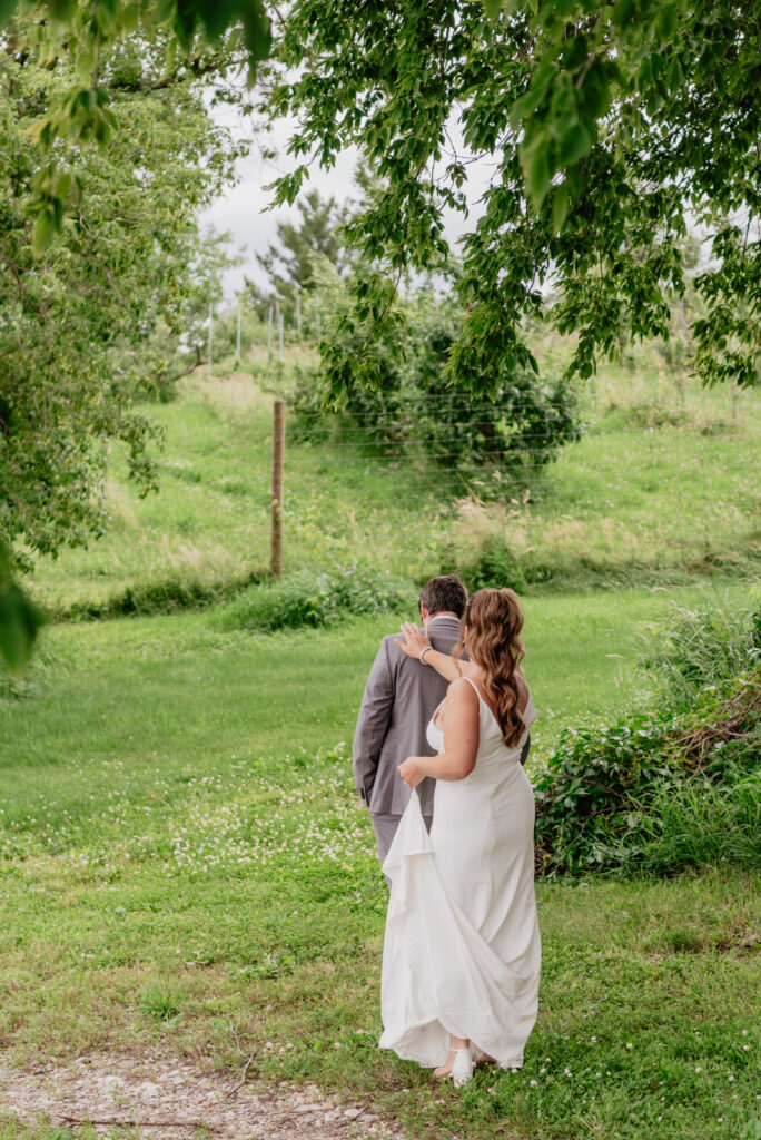 bride and groom first look in meadow at Deer Lake Orchard