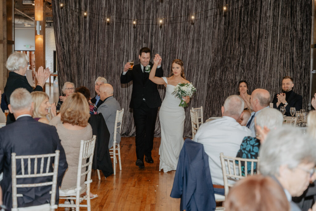 bride and groom cheering during grand entrance at JX Venue