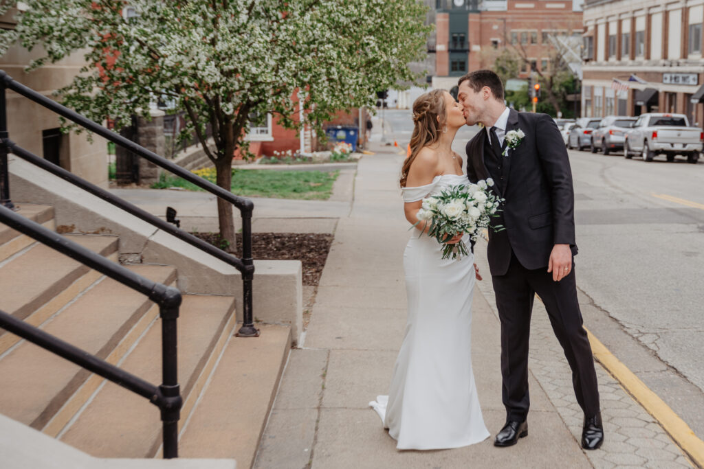 bride and groom kissing outside of JX Venue