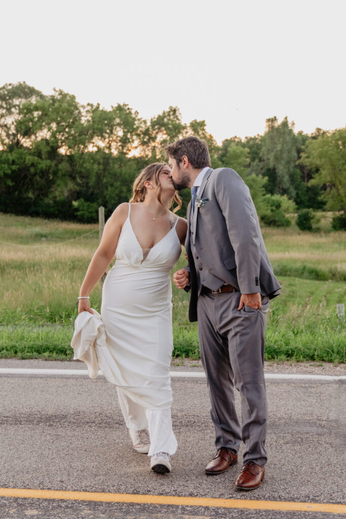 bride and groom playful kiss during sunset photos