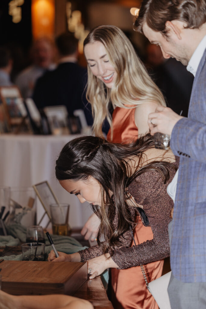 guests signing guest book during cocktail hour