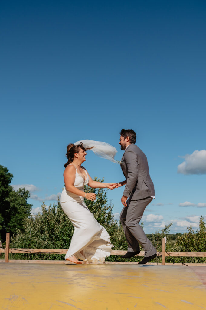 bride and groom playful portraits at Deer Lake Orchard on bounce pad