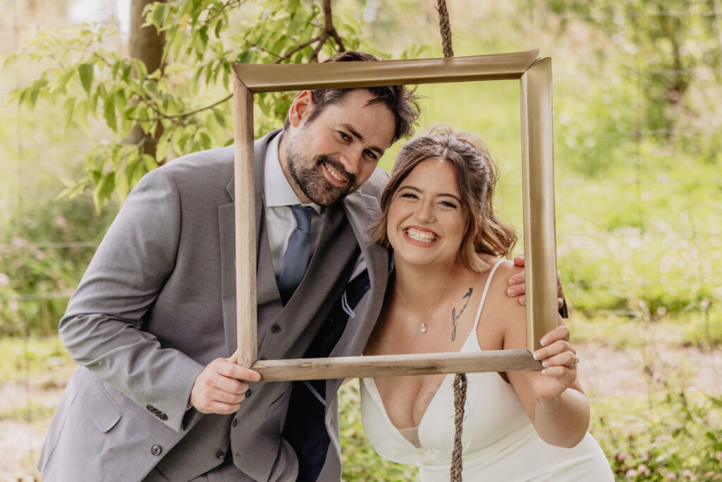 fun bride and groom portrait with hanging frame