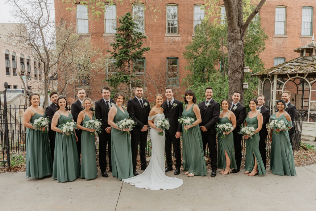 classic timeless wedding party photo in front of brick building