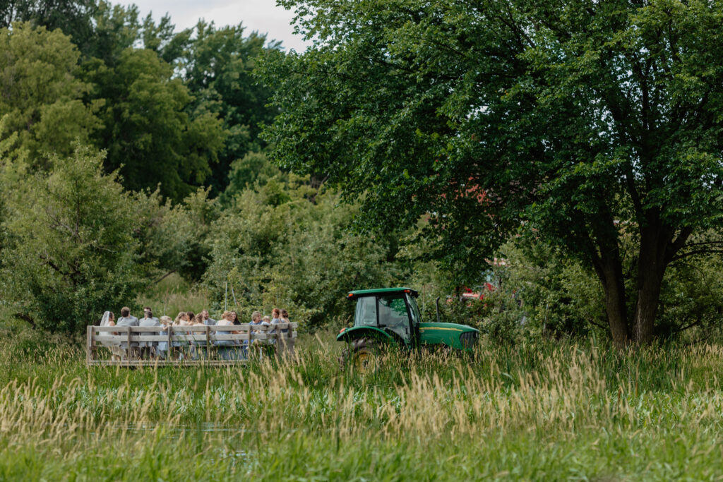 tractor pulling hayride full of guests to Deer Lake Orchard ceremony site