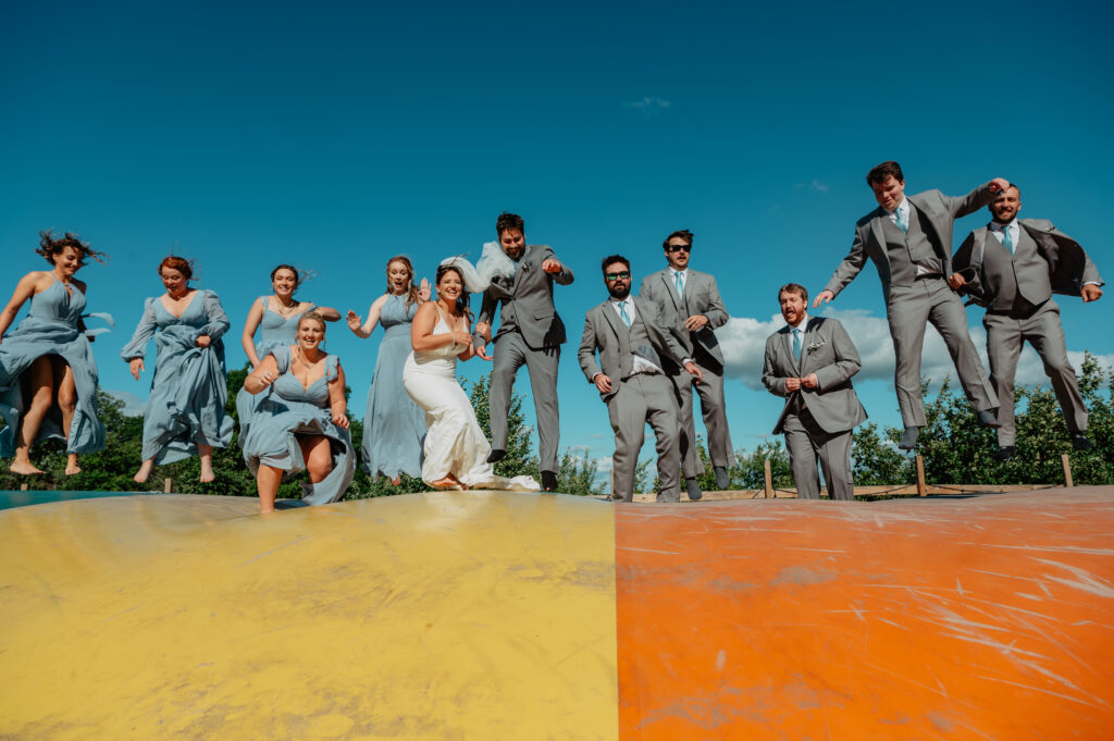 fun playful wedding party portrait on bounce pad at Deer Lake Orchard